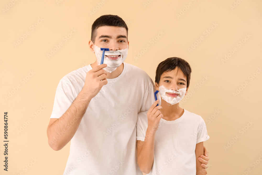 Father and his little son shaving against beige background