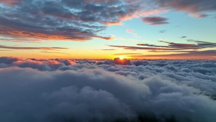 Wall Mural - Sun goes into the clouds. Epic sunset in the sky, aerial shot. Flying above the clouds illuminated by the evening sun