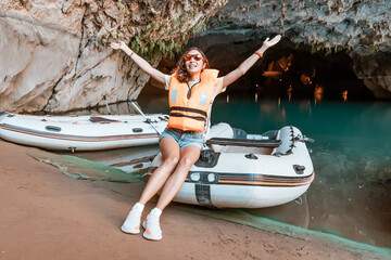 Wall Mural - girl at the excursion boat in the cave lake appears to be quite adventurous as she explores the depths of the dark cave and navigates the boat through the winding waterways.