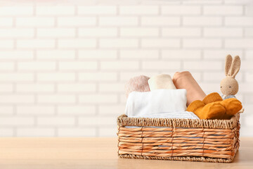 Wall Mural - Basket with baby clothes and toy on wooden table