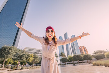 Wall Mural - Let your senses be dazzled by the juxtaposition of an Indian woman's flowing dress and the sleek lines of Abu Dhabi's towering skyscrapers.