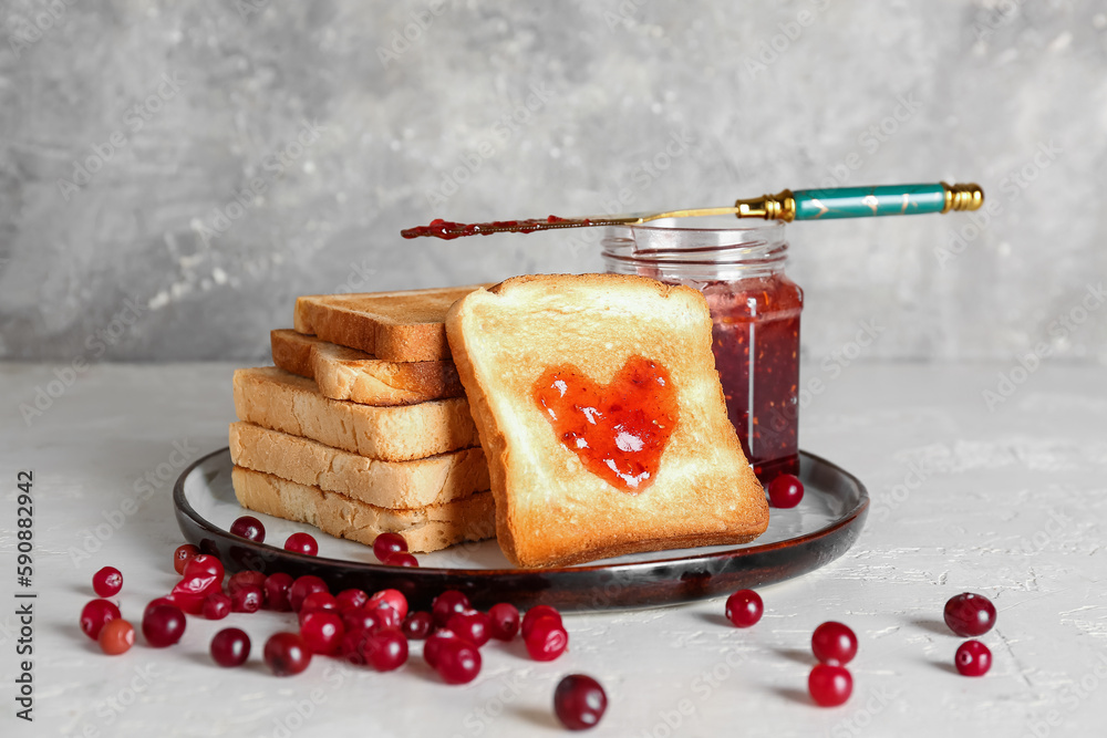 Plate of tasty toasts with cranberry jam on table