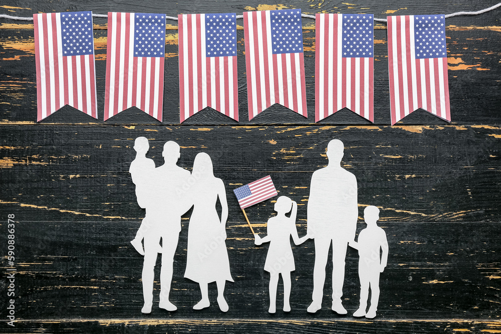 Family figures with USA flags on dark wooden background. Memorial Day celebration