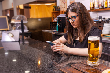 Side view of a waiter taking a break using phone in restaurant