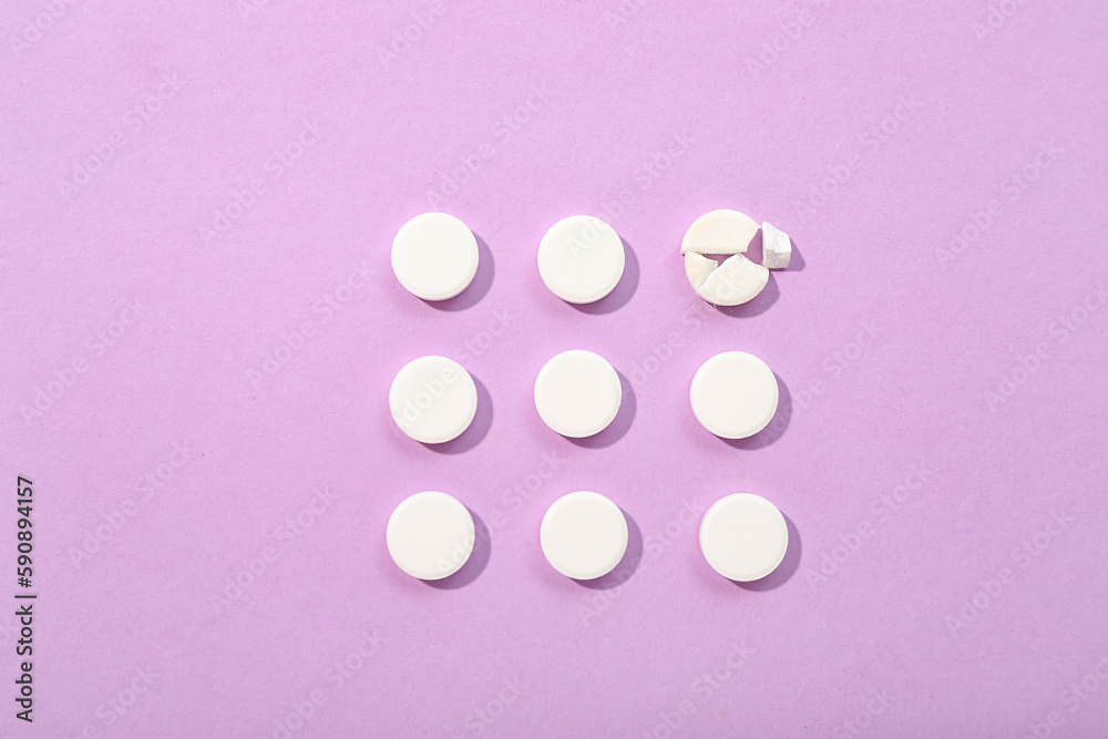 White pills on lilac background