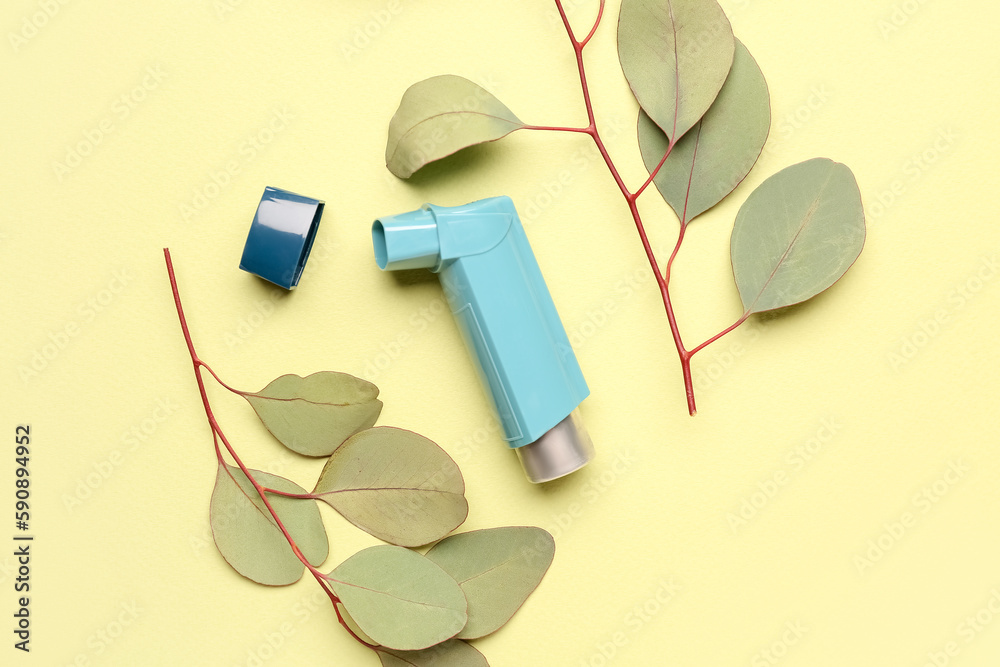 Asthma inhaler with eucalyptus branches on green background
