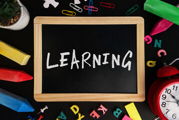 Aufkleber - Wooden board with Learning text on a background of various colorful subjects