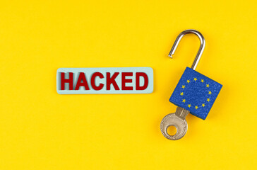 Poster - On the yellow surface is an open lock with a key and a sticker with the inscription - hacked