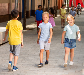 Wall Mural - Positive little boy and his sister walking together on the street