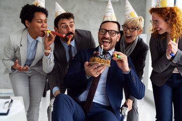 Group of business people celebrating birthday of his colleague at office