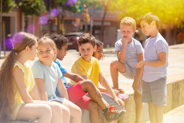 Wall Mural - Group of children of different nationalities communicate on a city street