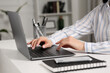 © New Africa - Woman working with laptop at white desk indoors, closeup