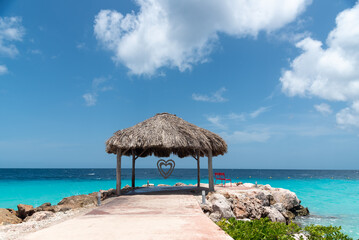 Wall Mural - Turquoise beach with a roof on the shore to protect from the sun on the island of Curacao. Netherlands Antilles.