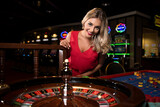 Fototapeta Tulipany - Portrait of a Woman Gambling Roulette in Casino