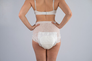 Wall Mural - Rear view of a woman in adult diapers. Incontinence problem.