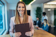 © Mediteraneo - Portrait of a businesswoman standing in the office.