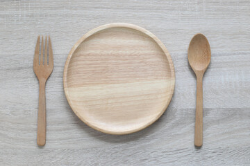 Wall Mural - Wooden bowl with spoon and fork on wooden background