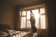 © 18042011 - Woman stretching in the morning  by the bed, in front of large window,  free copy space  AI generated