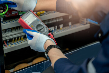 Wall Mural - Electrical engineers using measuring them with a multimeter test electrical installations and wiring on protective relays.