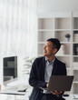 © Kritdanai - Happy working asian businessman talking on the phone with accounting documents at desk in happy working office