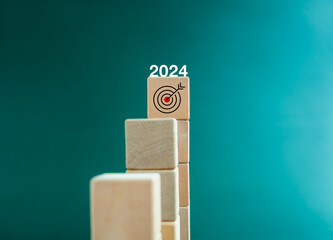Poster - Goal and success. 2024 calendar years number on target icon on top of wooden cube blocks, bar graph steps. Business growth process, development, leadership, marketing, economic improvement concepts.