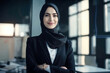 Beautiful muslim business woman in hijab keeping arms crossed, smiling and looking at camera in modern office. Generative AI