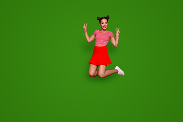 Poster - Full-length full-size view of jumping laughing and pretty woman dressed in colourful bright clothes shows a v-sign isolated on red background. Joy fun concept