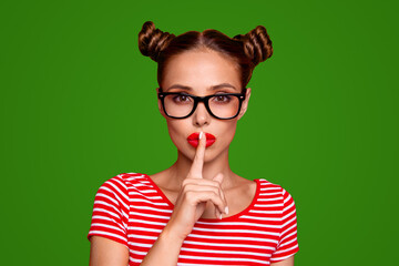 shh portrait of attractive mysterious girl in glasses gesturing silence sign with forefinger red pou