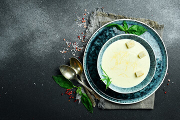 Wall Mural - Homemade cream cheese cream soup, in a bowl. On a dark background, close-up.