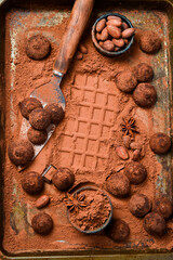 Wall Mural - Sweet chocolate truffles with cocoa powder. On a dark chocolate background. Cocoa beans.