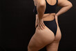 © Юля Бурмистрова - Overweight woman in black underwear pull up panties, back view. Flaunt figure imperfections, cellulite hips. Studio portrait over black background. Concept of obesity, body positive, self acceptance.