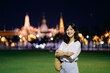 © Jirawatfoto - Portrait young beautiful asian woman smiling while travel at Temple of the Emerald Buddha or Wat Phra Kaew in night view point, Bangkok, Thailand.