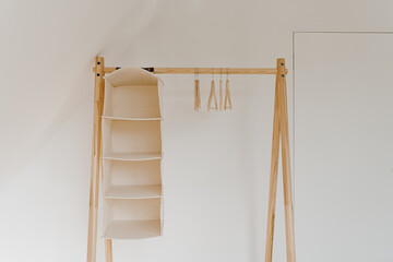 Empty hangers on floor hanger over white wall. Minimalist home interior concept with wardrobe. Online fashion store, online shop background