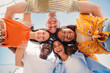 © Jose Calsina - low view angle of a group of multiracial teenagers smiling and looking at camera together. Portrait of five young students smiling and laughing. Cheerful people having fun and embracing each others