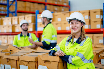 beautiful young warehouse woman worker stand in front of her co-worker men and look at camera with s