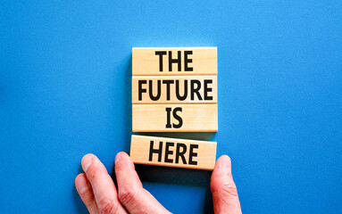 Wall Mural - The future is here symbol. Concept words The future is here on wooden block. Beautiful blue table blue background. Businessman hand. Motivational business the future is here concept. Copy space.
