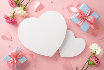 Wall Mural - Celebrate Mother's Day in style with top view flat lay photo with gift boxes tied with pink ribbon, delicate carnation flowers, and pink paper hearts on a soft pink background with two hearts for text