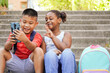© Komuso & Colorsandia - Happy multiethnic children using mobile phone for vlogging. New generations of influencers streaming out social media content, childhood, fun, two