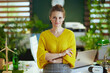 © Alliance - smiling elegant business owner woman standing in green office