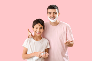 Poster - Man and his little son applying shaving foam onto faces against pink background