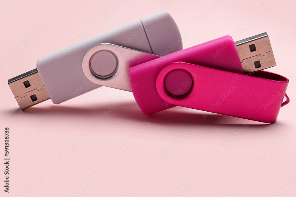 USB flash drives on pink background