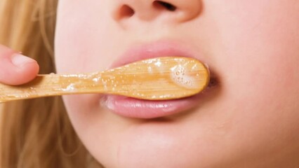 child girl or girl of seven years old brush her teeth with eco toothbrush made of natural materials.