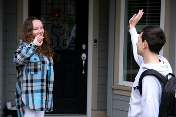 Young people, man and woman greeting or saying goodbye by waving hands in the park. High quality photo