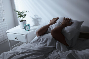 Sticker - Sleepy man covering head with pillow in bed at home