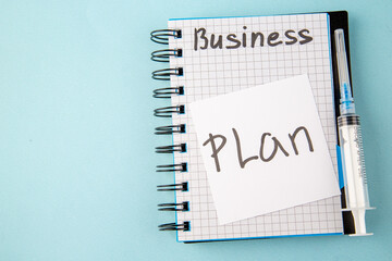 Wall Mural - top view open copybook with plan note and injection on blue background color school virus health cov