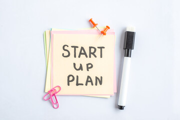 Wall Mural - top view start up plan note on sticker inside open copybook on gray background school lesson student