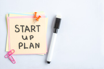 Wall Mural - top view start up plan note on sticker inside open copybook on gray background school lesson student