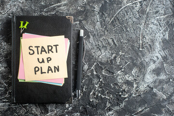 Wall Mural - top view start up plan note on sticker with copybook on gray background lesson student note notepad 