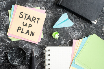 Wall Mural - top view start up plan note on sticker with copybook on gray background lesson student notepad note 