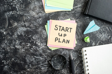 Wall Mural - top view start up plan note on sticker with copybook on gray background lesson student notepad note 